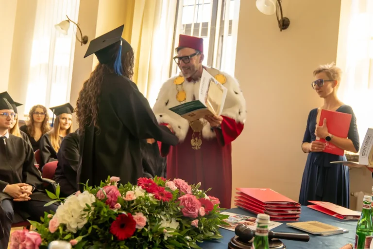 Zdjęcie przedstawiające Rektora Wyższej Szkoły Nauk o Zdrowiu w Bydgoszczy dr. n. med. Pawła Rajewskiego, prof. WSNoZ, MBA wręczającego dyplom studentowi fizjoterapi